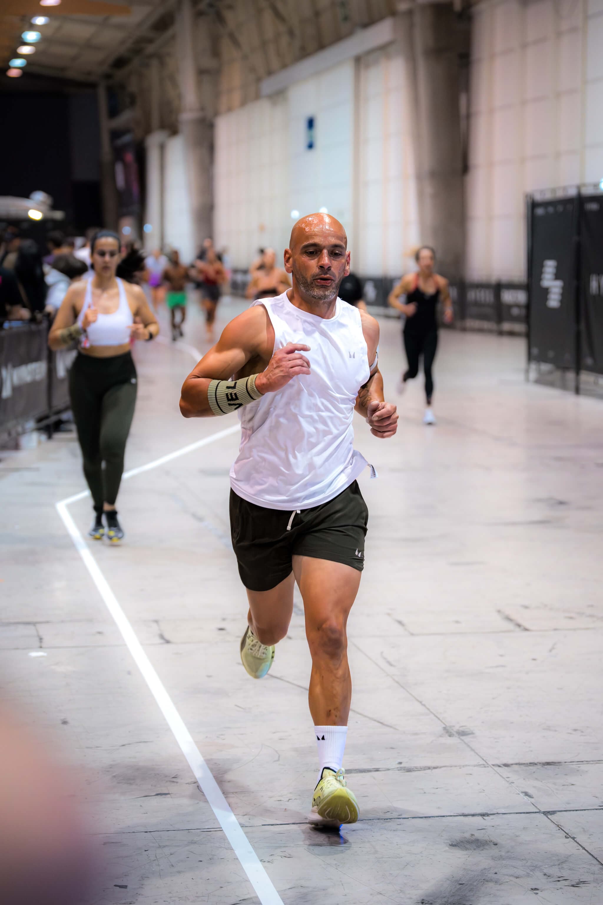 RoxZone athlete running between HYROX workout stations