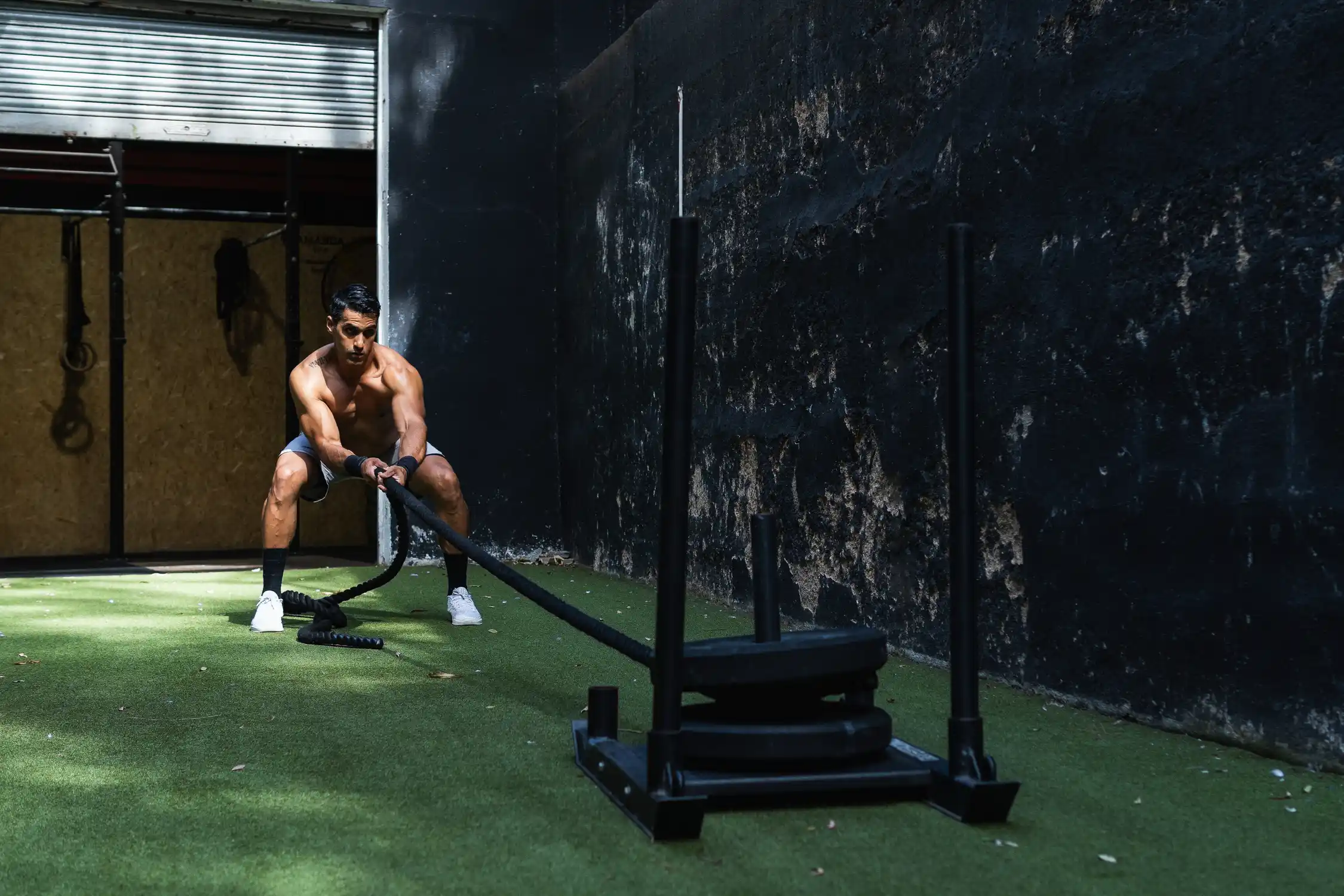 Athlete performing an outdoor sled pull, replicating a HYROX functional station within a minimalist hybrid training plan.
