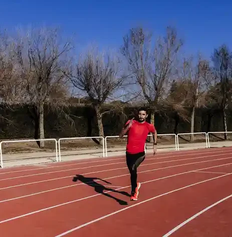 Athlete performing running intervals on a track for HYROX training