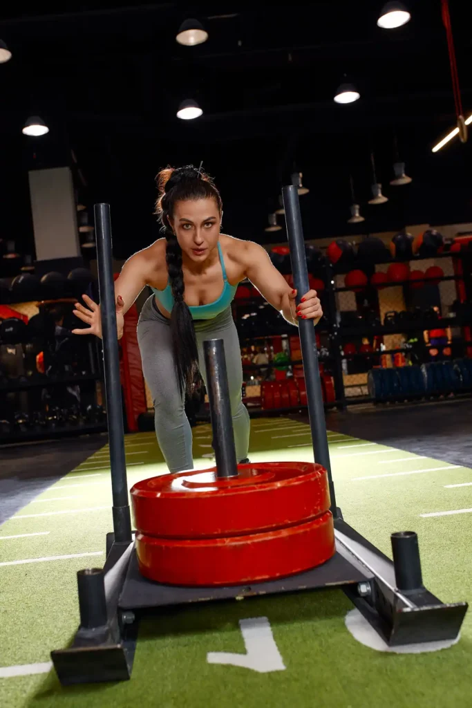 Athlete performing sled push as part of HYROX training programming
